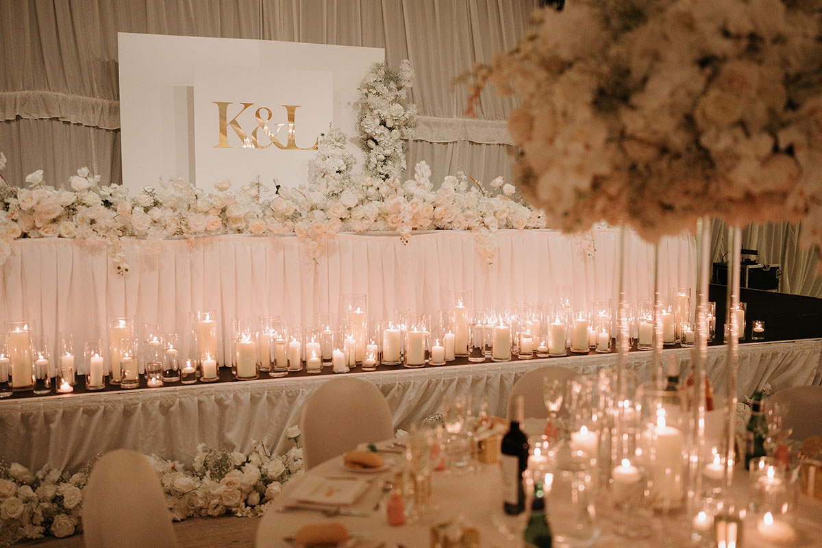 Raised top table with white floral arrangements and candlelight at Ingliston Country Club reception