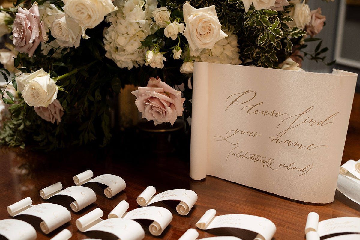 Wedding place cards and guest list display with floral arrangement at Signet Library
