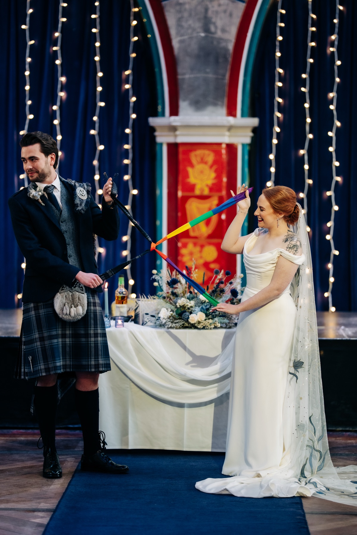 Robyn and James take part in a traditional Scottish handfasting ceremony at Òran Mór using rainbow ribbon from their Pride flag.