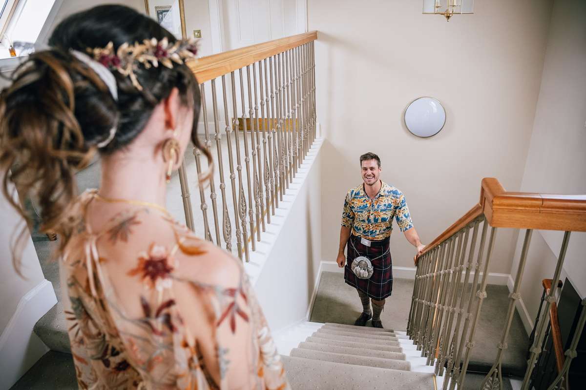 Couple sharing a first look on the staircase at Ardoch Loch Lomond, with the groom wearing a kilt