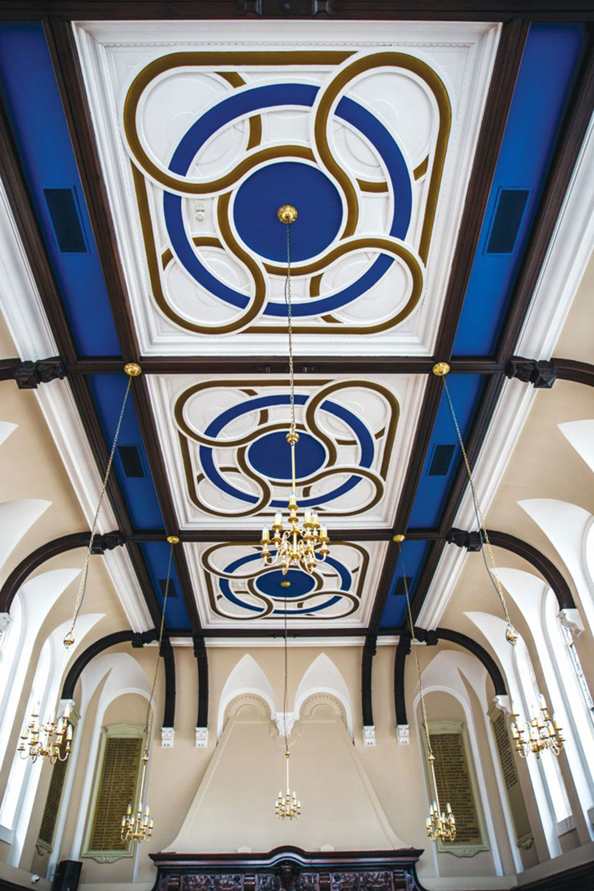 intricate details on the ceiling at 1599 at the royal college with blue paintwork and hanging chandeliers