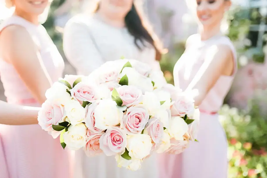Bridesmaids holding out bouquets