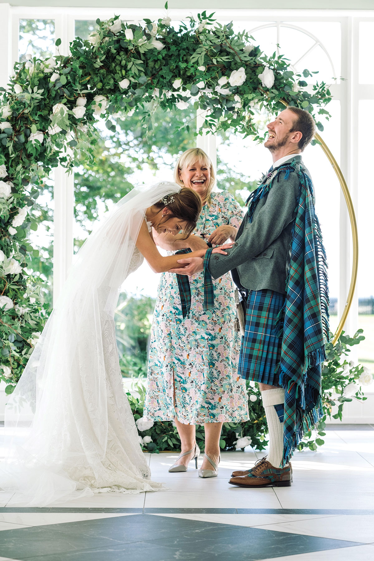 celebrant niki smith laughs next to bride and groom at lochgreen house hotel in ayrshire