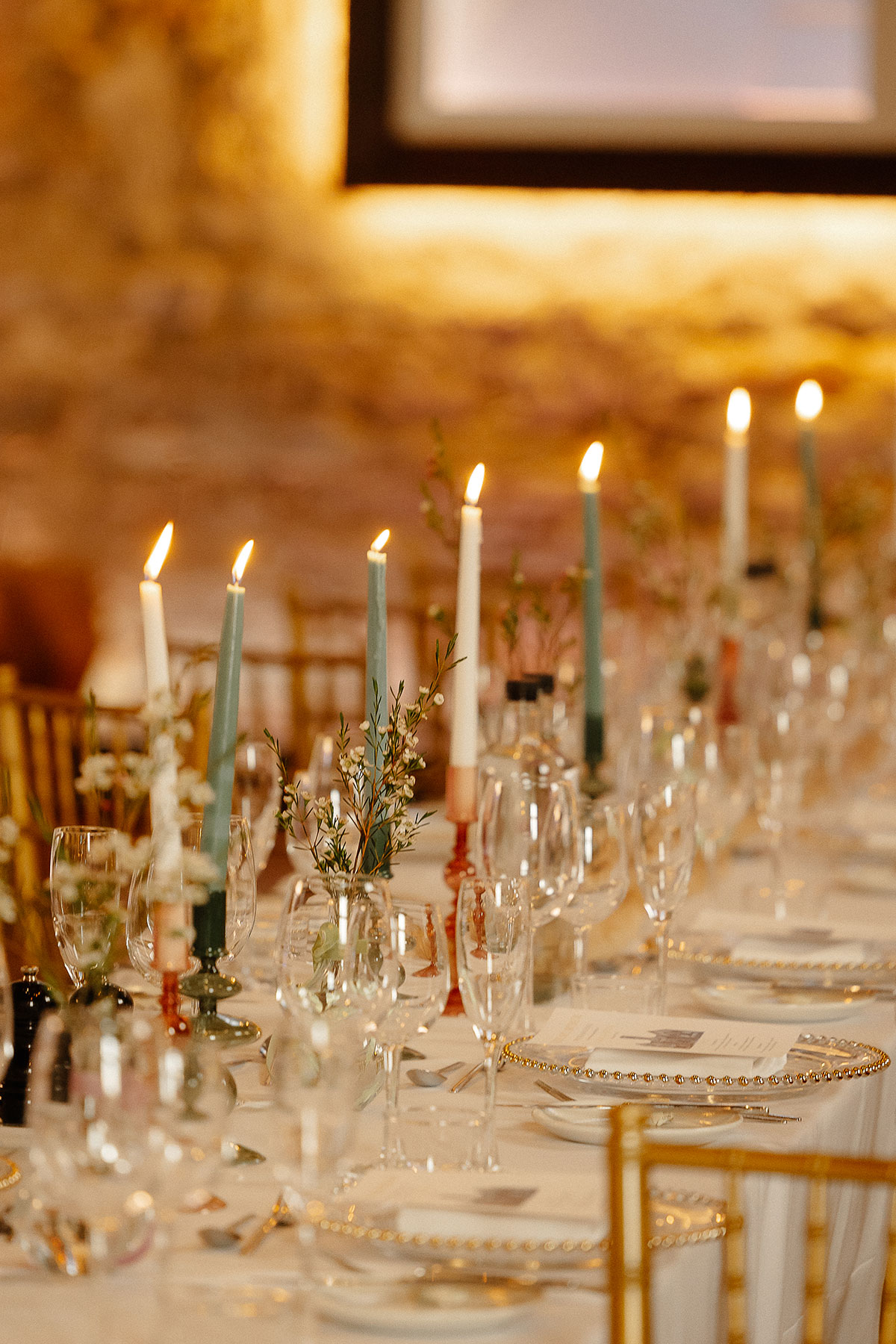 Candlelit wedding table decor at Greyfriars Hall, Virgin Hotels Edinburgh, with gold chairs, pastel taper candles and soft floral styling.