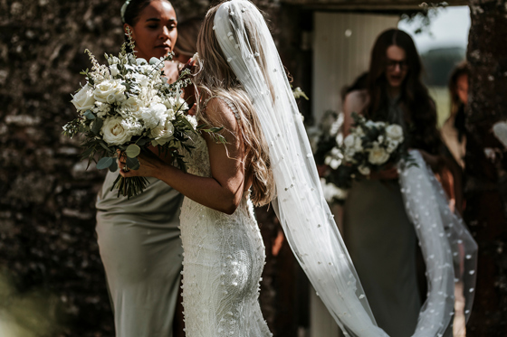 Bride holding a large white rose bridal bouquet moments before walking down the aisle at a Scottish wedding