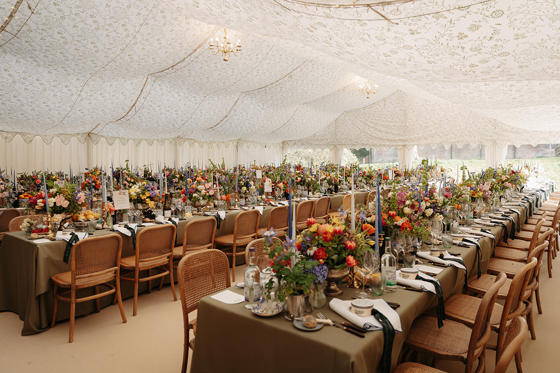 Marquee wedding reception with long tables, colourful flowers and candles styled by Pebblefish Occasions & Events.