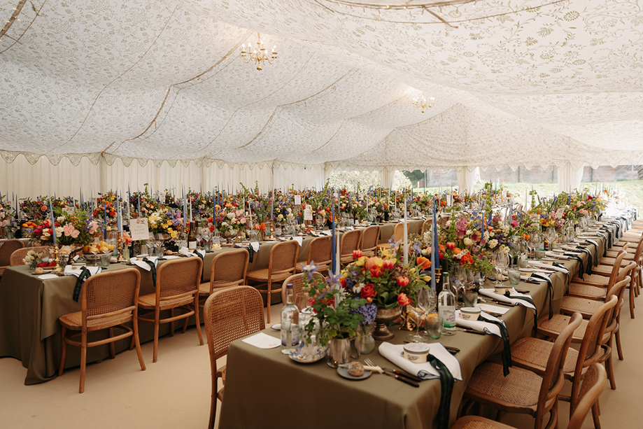 Marquee wedding reception with long tables, colourful flowers and candles styled by Pebblefish Occasions & Events.