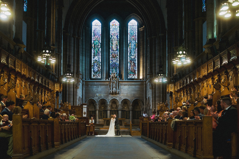 1. Newlyweds kissing at the altar during a church wedding ceremony planned by Pebblefish Occasions & Events.