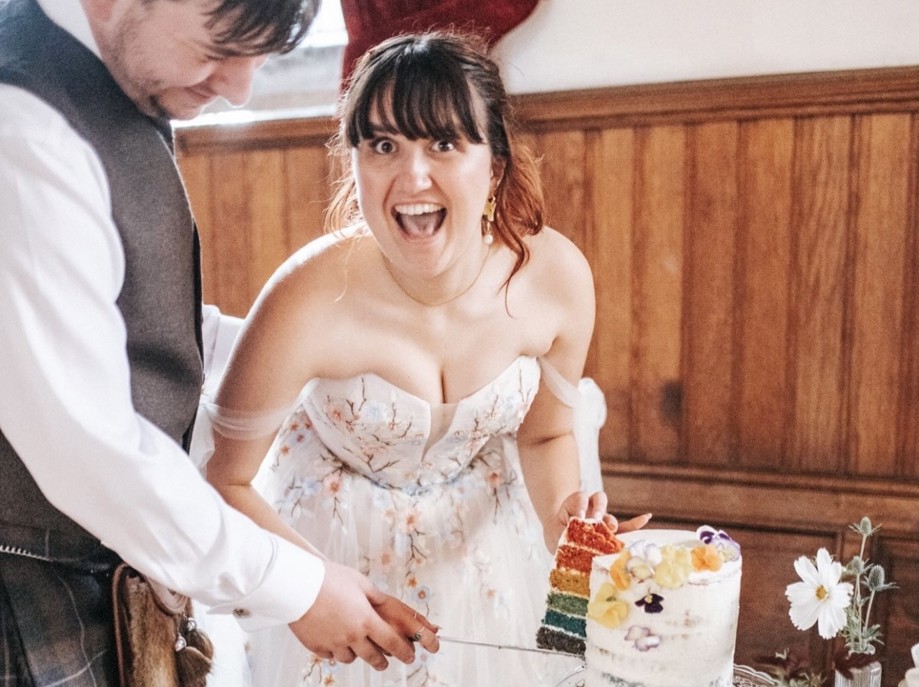 Couple excited after their humanist wedding ceremony cutting their cake
