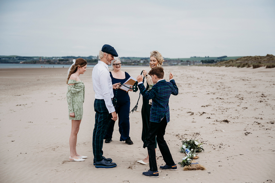 Relaxed Scottish beach wedding on West Sands, St Andrews, with a humanist celebrant leading a family-inclusive handfasting ceremony by the sea.