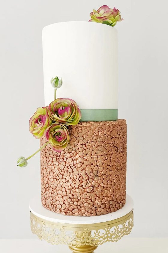 Two-tier cake with copper and sage green accents with pink and green flowers