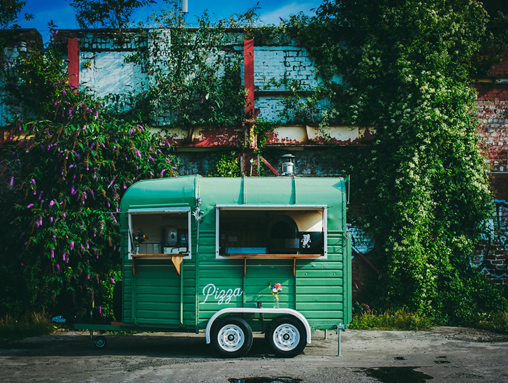 Green Dough Man's Land horsebox in front of leafy, floral background