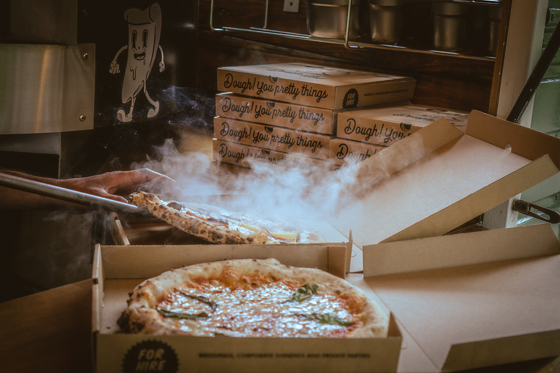 Pizza boxes with fresh pizza and steam