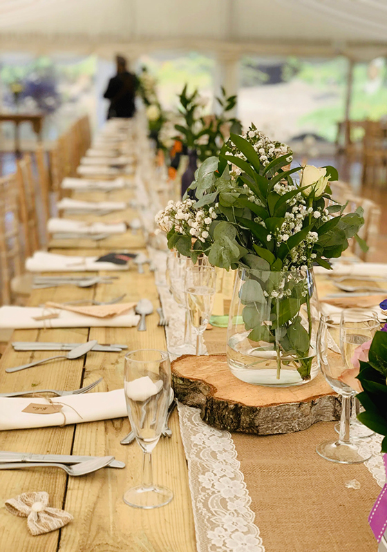 Rustic marquee wedding table styled with greenery, florals and glassware by Food Creations
