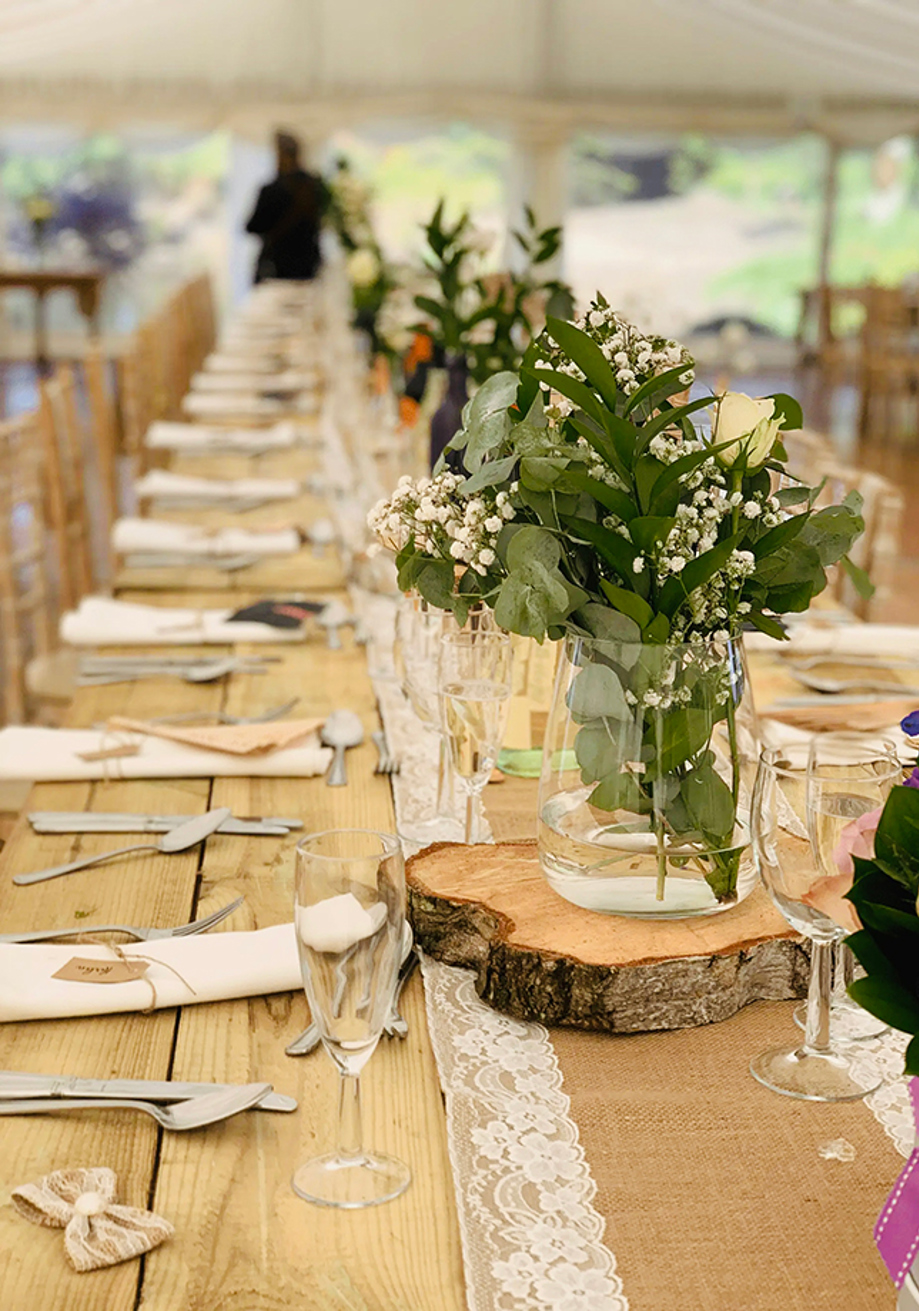 Rustic marquee wedding table styled with greenery, florals and glassware by Food Creations