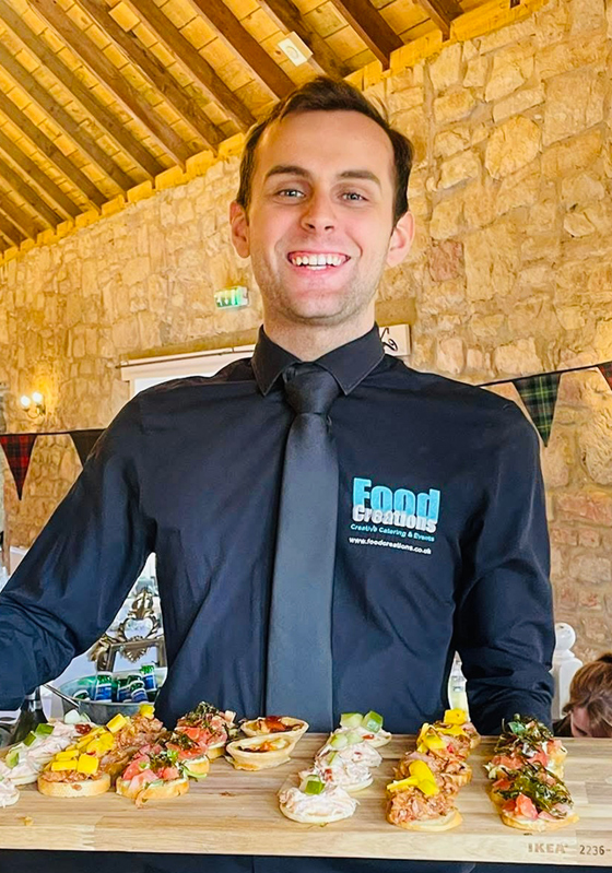 Food Creations wedding catering team member serving colourful canapés