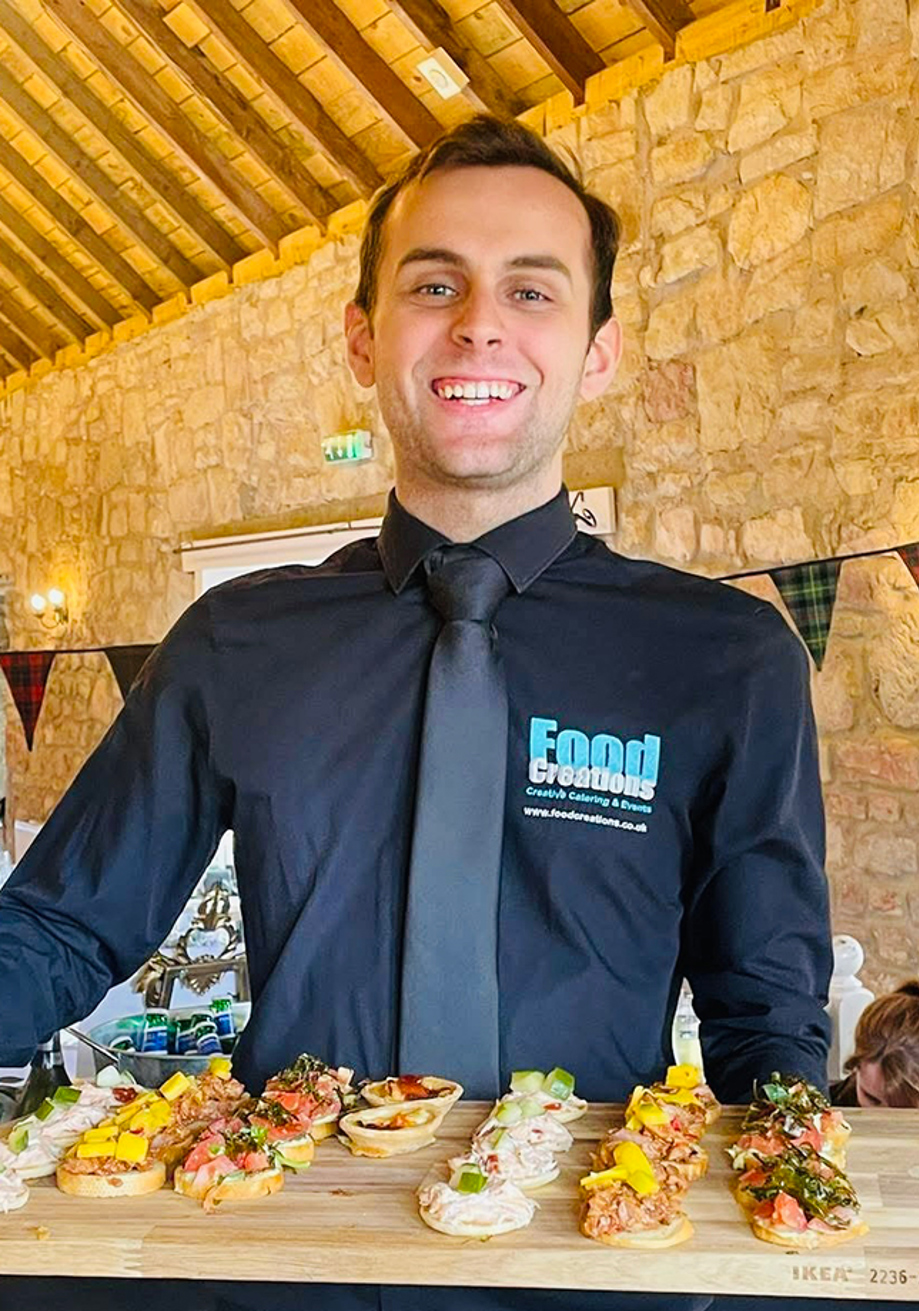 Food Creations wedding catering team member serving colourful canapés
