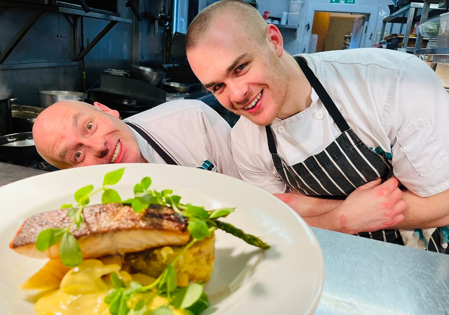 Food Creations chefs presenting a plated wedding dish in the kitchen