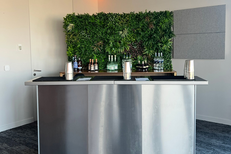 Portable stainless steel cocktail bar by Sips Events with greenery backdrop for corporate events and weddings.