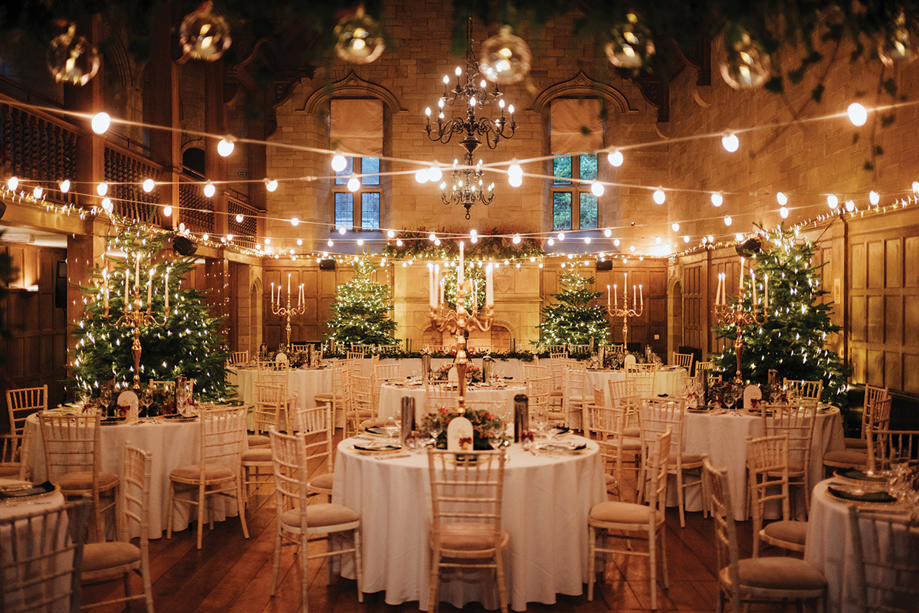 Wedding meal set up at Christmas, with christmas trees and candelabras in background.