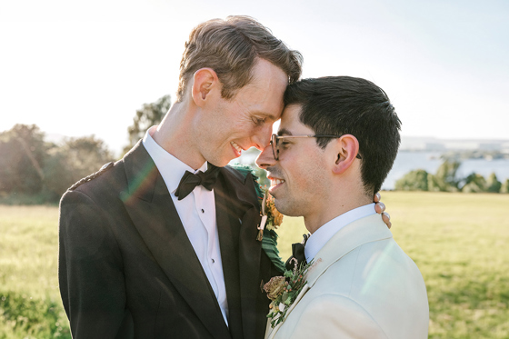 Same-sex couple sharing a relaxed wedding portrait in the Scottish countryside