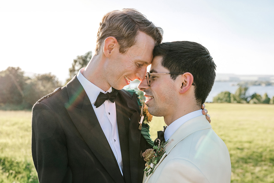 Same-sex couple sharing a relaxed wedding portrait in the Scottish countryside