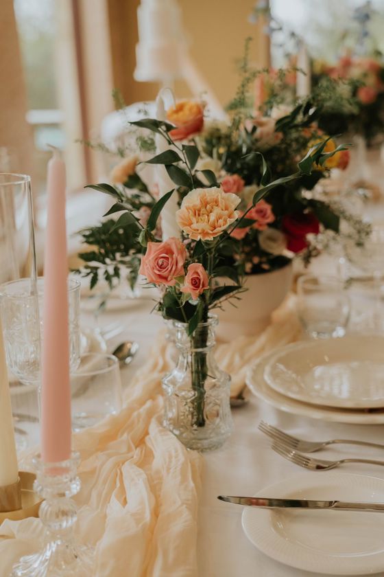 Peach and pink flowers in vase on wedding meal table