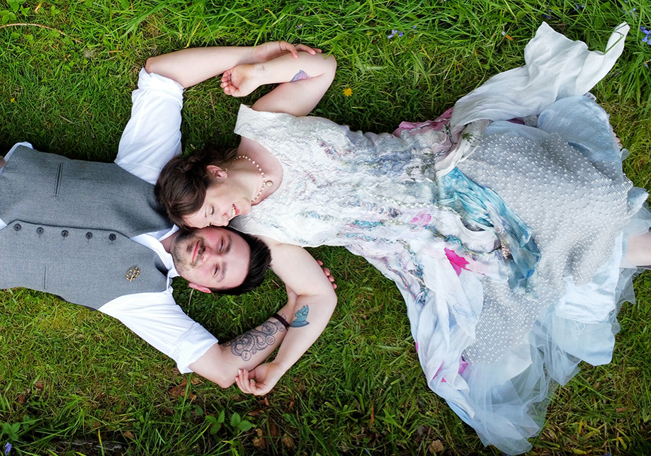 Bride adn groom laying on grass together. Drone wedding photograahy 