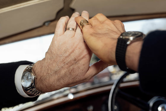 Two grooms hands with car interior in background