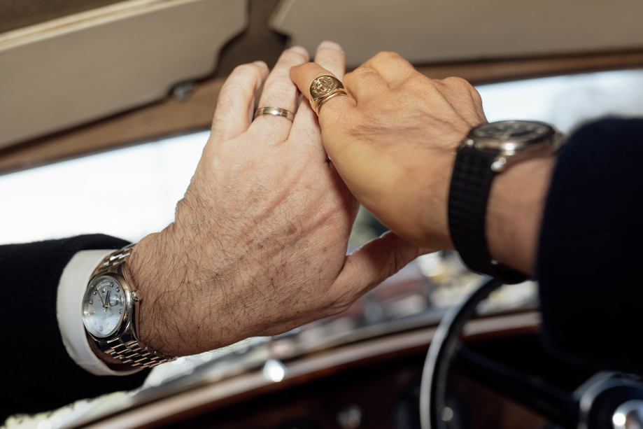 Two grooms hands with car interior in background