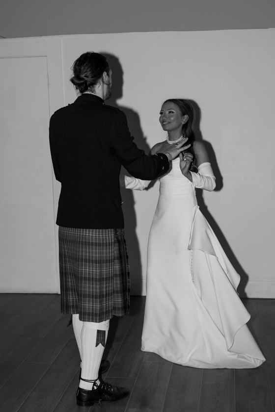 Black and white image of bride and groom dancing by Aela Photography