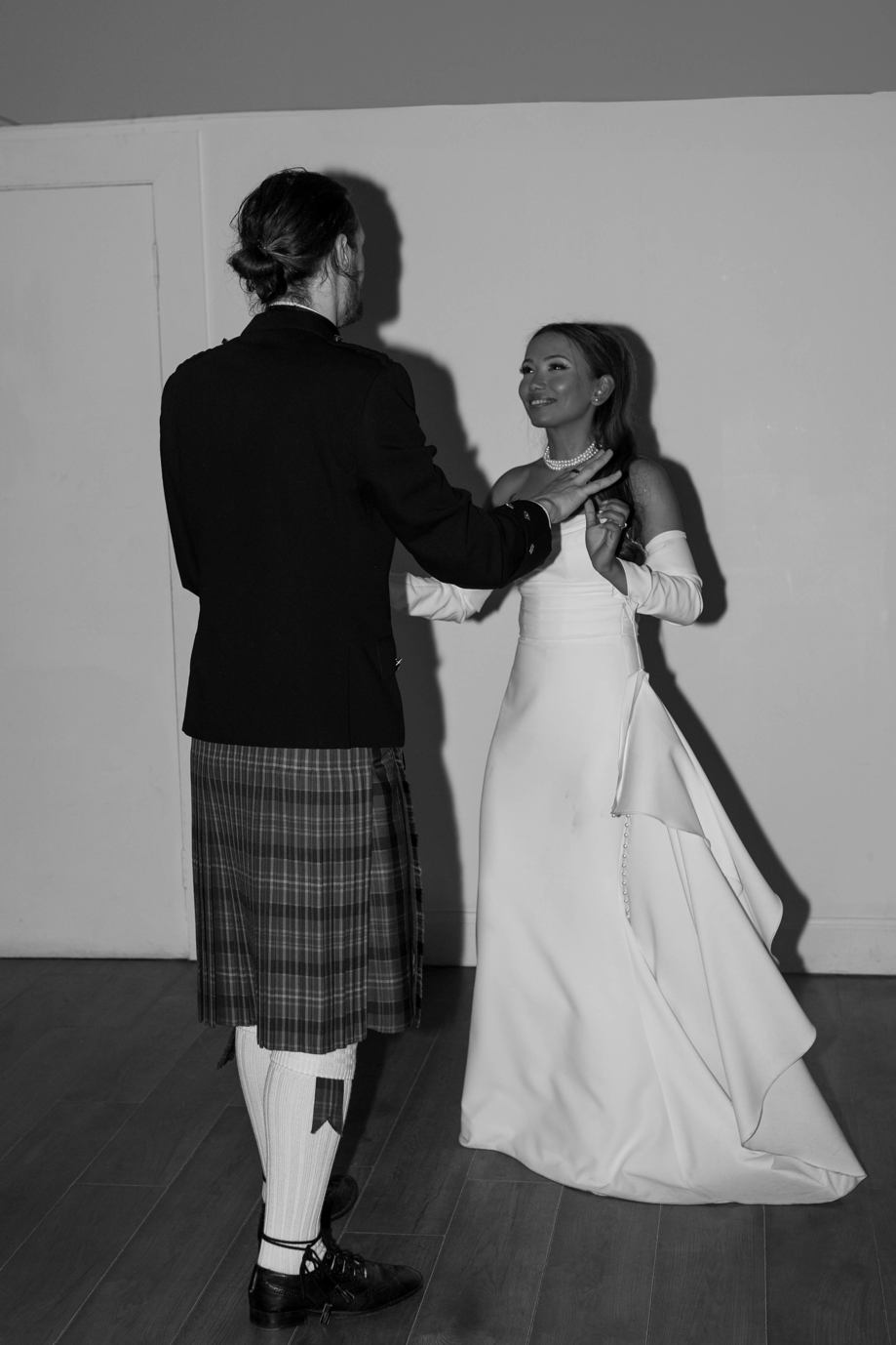 Black and white image of bride and groom dancing by Aela Photography