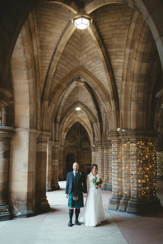 Bride and groom standing in Glasgow University cloisters