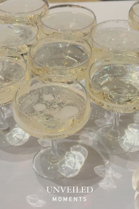 Portrait image of champagne glasses with "Unveiled Moments" at bottom of image