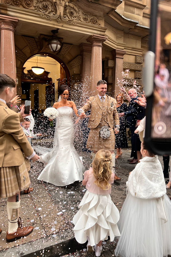 Bride and groom leaving venue after ceremony through confetti by Unveiled Moments, Scottish wedding content creator