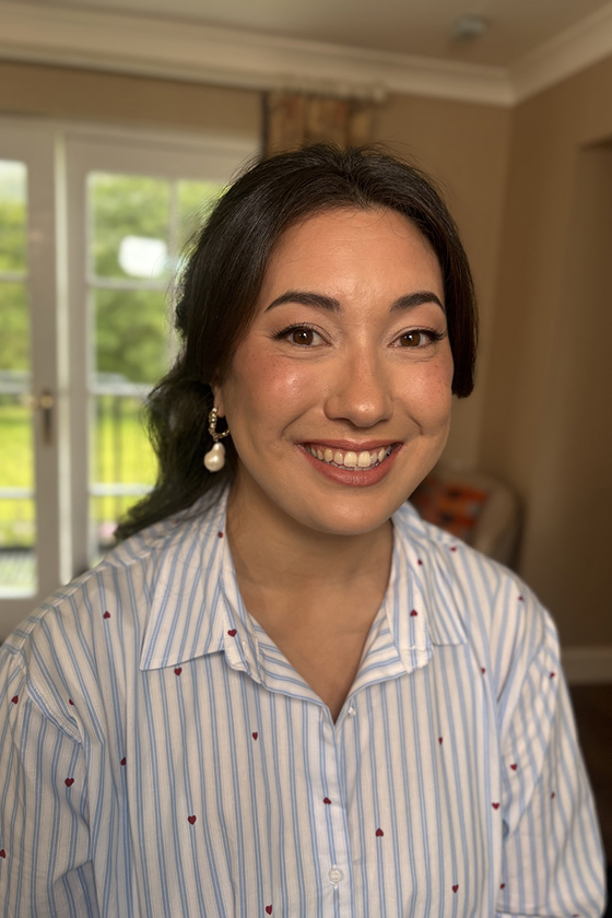 Bride in pyjamas smiles with makeup by Jill Rowan,