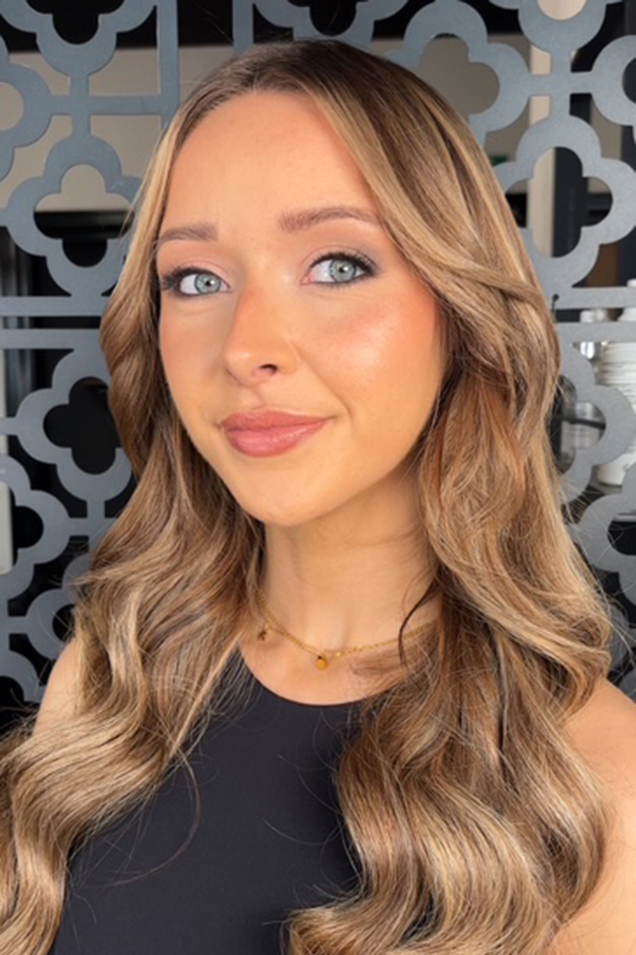 Bride with bronde hair and blue eyes smiles after getting her makeup done by Jill Rowan Makeup.