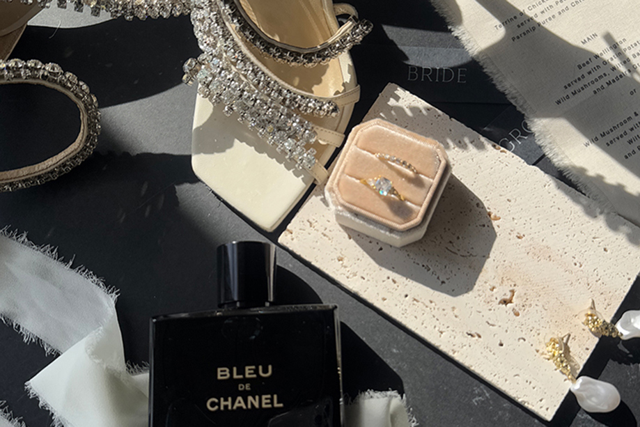 Detail shot of Jimmy Choo wedding shoes, rings, perfume and menu by The Perfect Day Club, a wedding content creator in Scotland.