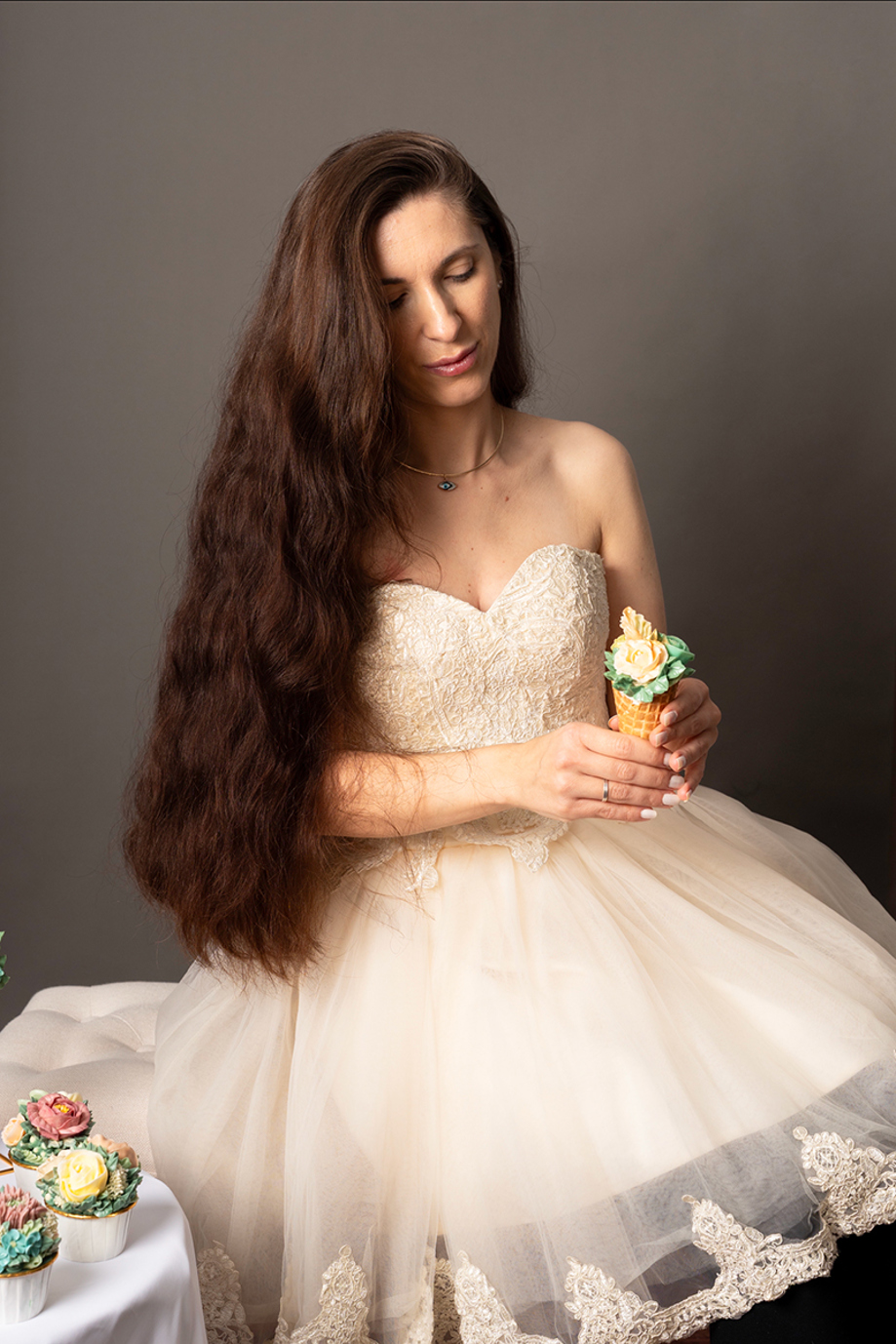Eclectic Luxuries - Artisan Couture Cakes owner Gabby poses in dress with hand-piped buttercream cone.