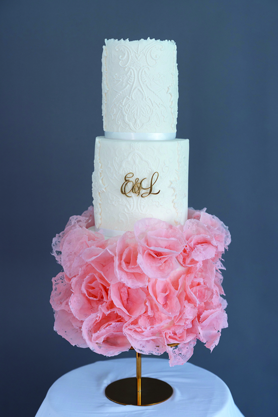 Three-tier white cake inspired by bride's wedding dress with gold letters on second tier and third tier made of pink wafer paper by Eclectic Luxuries