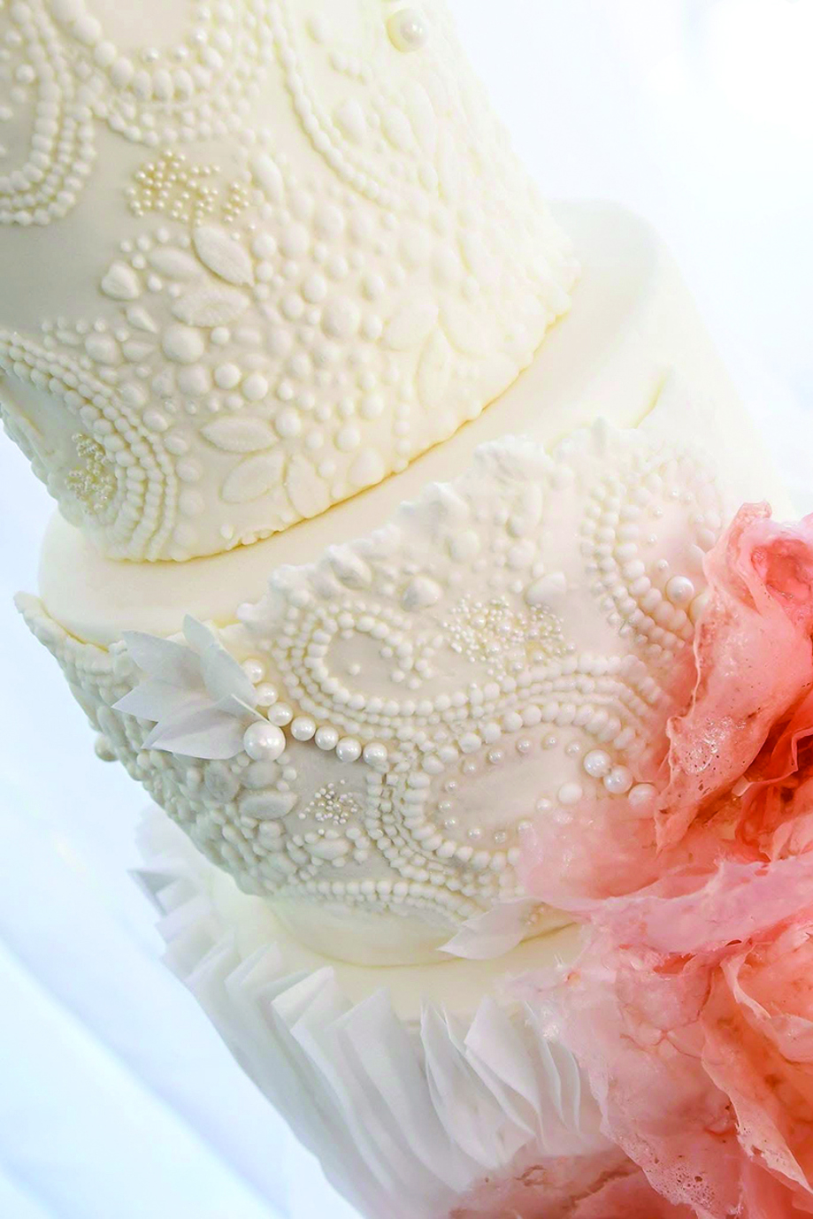 Three-tier cake inspired by the bride's wedding gown with intricate beading, ruffles and pink wafer paper by Eclectic Luxuries