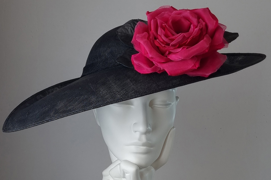 Black hat with cerise rose at Hazel Goodwin Millinery in Glasgow city centre
