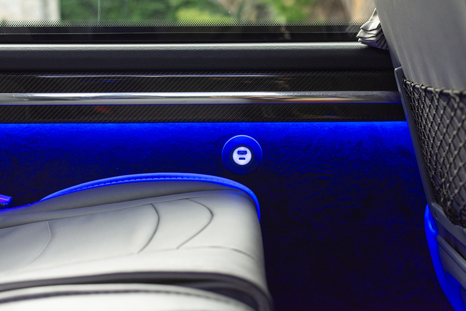 Blue underlights beneath window on Anderson Black Executive Travel minibus, with USBC charging port