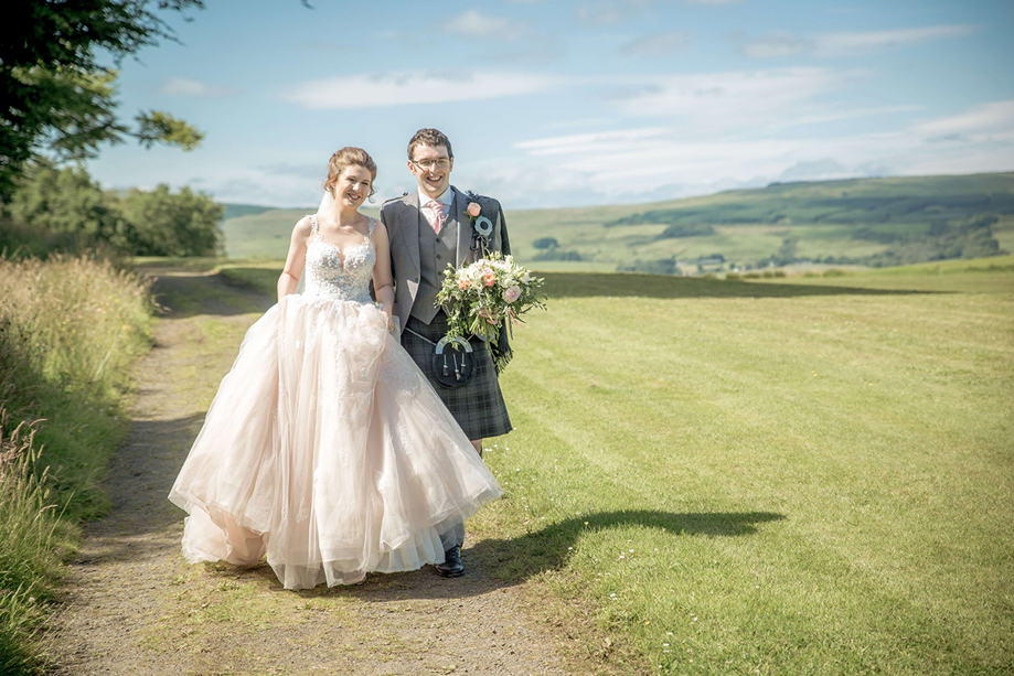 Newlyweds walking together through the countryside after their wedding, with planning and coordination by DSW Weddings