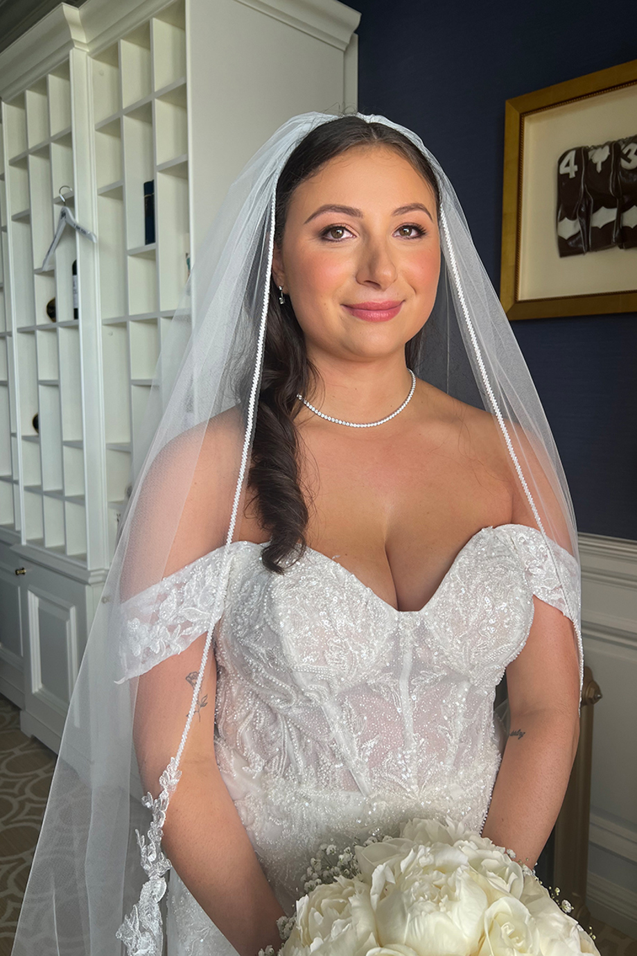 Bride smiling indoors with glowing natural bridal makeup and veil, created by Hannah Inglis Beauty