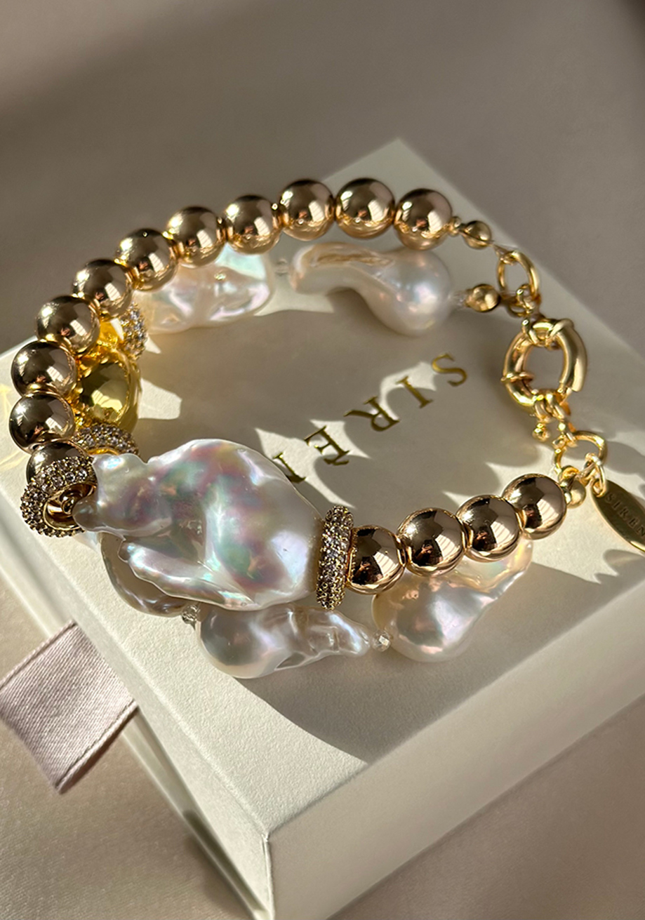Gold bead bracelet with large baroque pearl and crystal accents on jewellery box