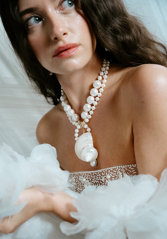 Close-up of statement pearl necklace with large shell pendant on bridal look