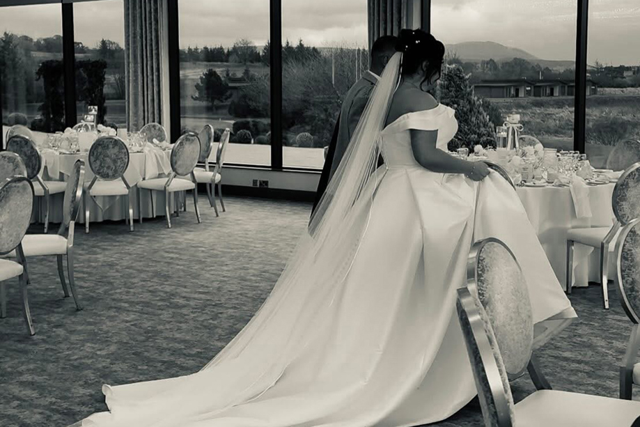 Black and white wedding content image of bride and groom walking into their wedding breakfast reception captured by Effortless Ivory Weddings