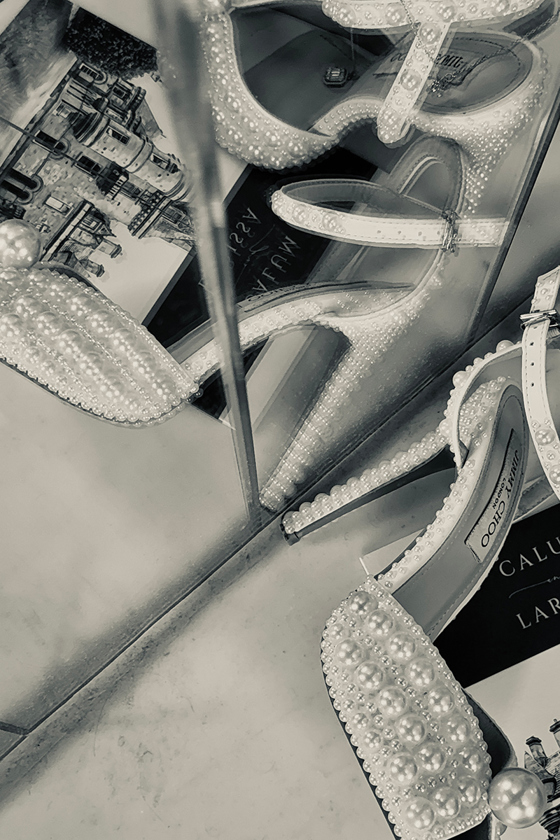 Black and white close-up of pearl embellished wedding heels and bridal accessories styled for wedding content creation by Effortless Ivory Weddings