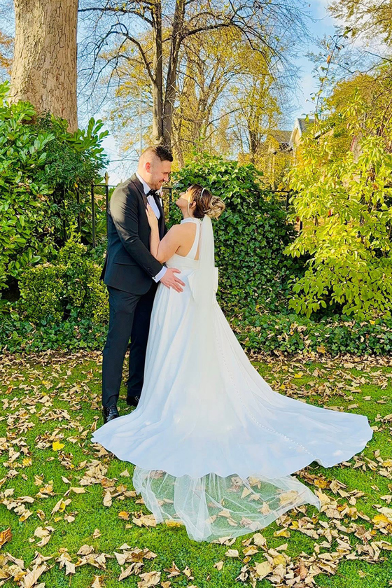 Bride and groom standing together in a sunny garden on their wedding day captured by Effortless Ivory Weddings